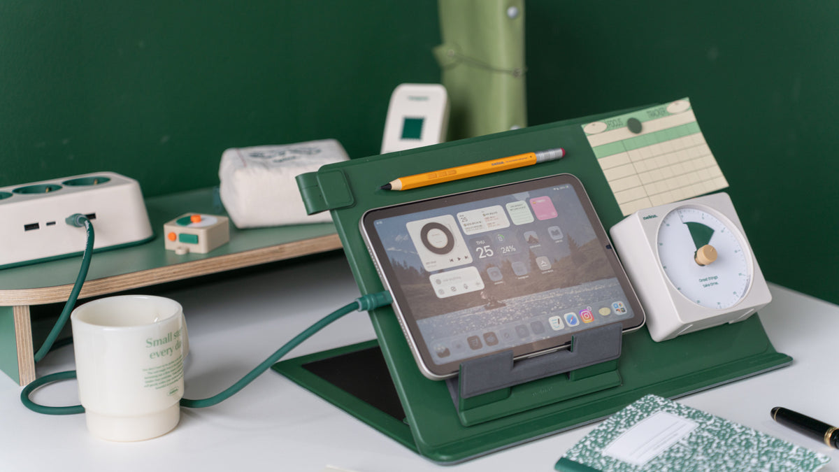 Nelna Anywhere Stand in deep green holding an iPad, paired with the Focus-on Timer and Pencil for iPads on a clean desk setup.